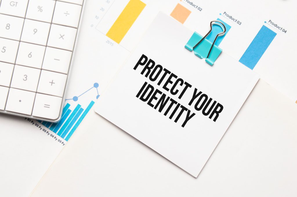 Secure your tax return with an IP PIN - Protect Your Identity text on a notepad with a calculator and financial charts in the background.