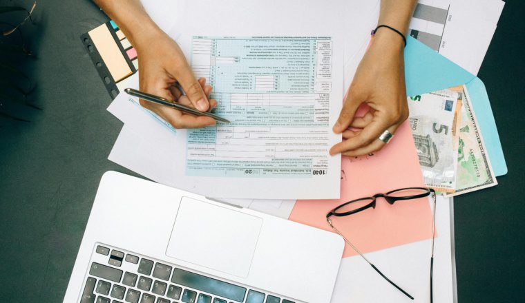 Small business owner reviewing Form 1099-K and online payment app reports under the $20,000 Form 1099-K threshold.